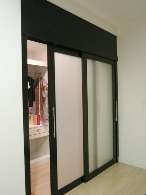 ประตูกั้นห้องบานสไลด์กั้นภายในเป็นห้องแต่งตัวมีราวและชั้นแขวนผ้า โครงไม้จริงงานBuilt in ย้อมสีโอ๊ค